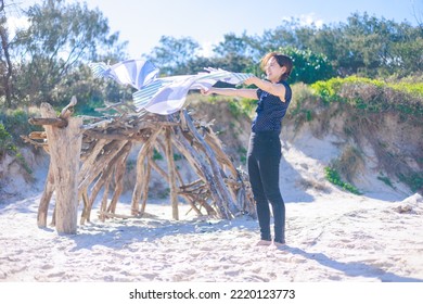 Woman Spreading A Beach Towel On The Beach