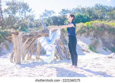 Woman Spreading A Beach Towel On The Beach