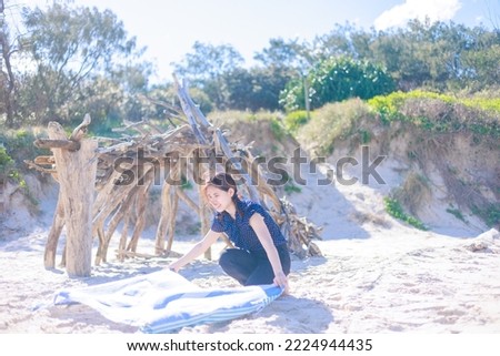 Woman spreading a beach towel on the beach