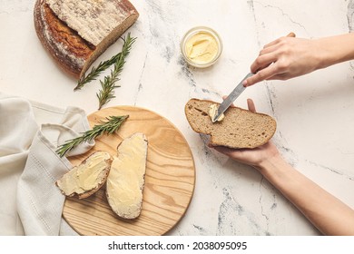 Woman spreading butter onto slice of fresh bread on light background - Powered by Shutterstock