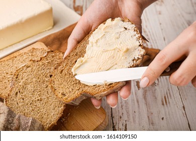 Woman Spreading Fresh Butter Onto Slice Of Bread