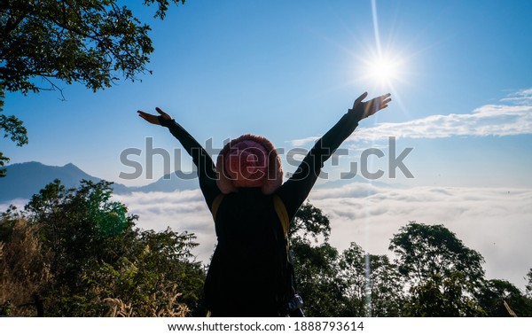 Woman spreading hands with joy and\
inspiration in\
mountains.\
