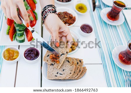 a woman is spreading tomato sauces onto the bread, only hands