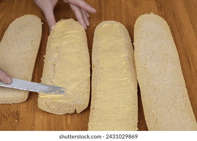 Una mujer esparce mantequilla sobre pan, baguettes para el desayuno de cerca