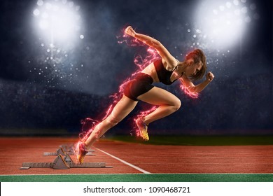 Woman Sprinter Leaving Starting Blocks On The Athletic Track. Exploding Start