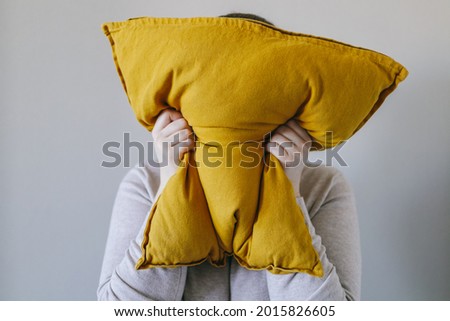 Woman squeezes a pillow with her hands, the concept of anger, irritation