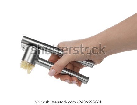 Woman squeezing garlic with press on white background, closeup
