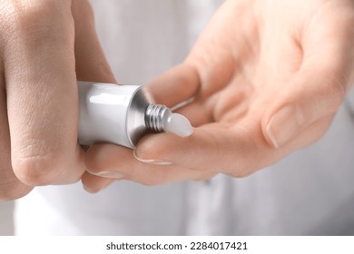 Woman squeezing out ointment from tube on her finger, closeup - Shutterstock ID 2284017421