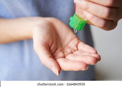 Woman Squeezing Sand Sanitizer Onto Her Hands From Bottle