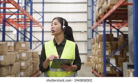 woman staff in reflective vest talking online phone call to help customers solving problem in storeroom with tablet - Powered by Shutterstock