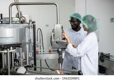 Woman Staff Worker Working Train African Black Man In Food Factory To Operate The Machine In Clean Production Room.