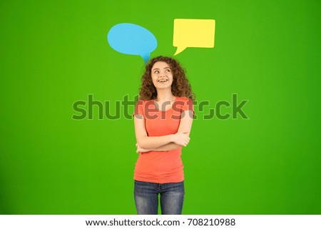The woman stand near dialog signs on the green background