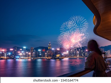 Woman Stand On Hotel's Balcony Watching The Firework Show In Victoria Harbor Hong Kong