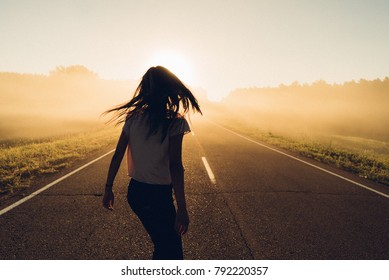 woman stand on the road with tree around, Asian traveler girl stand turn back on the road with sunshine and tree of parkland
