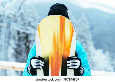 woman stand on the top of snowed hill and hide after snowboard - Shutterstock ID 787144909