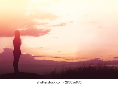woman standing alone at the field during beautiful sunset - Powered by Shutterstock