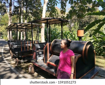 A Woman Standing Beside Model Train.