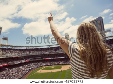 Woman standing and cheering at a baseball game