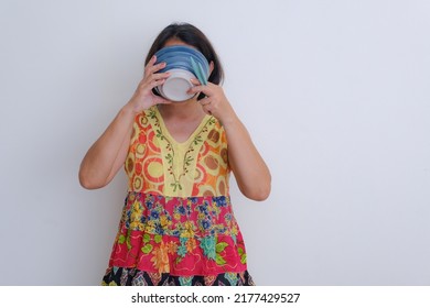 Woman Standing With Colorful Dress, Sipping Up A Bowl Of Soup