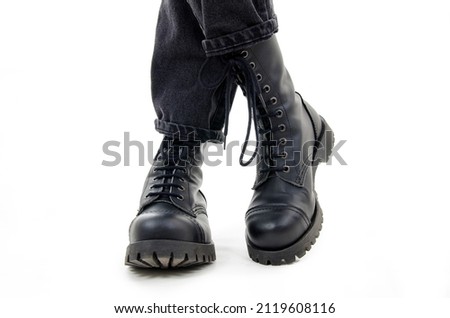 A woman standing in combat boots. Isolated on white background