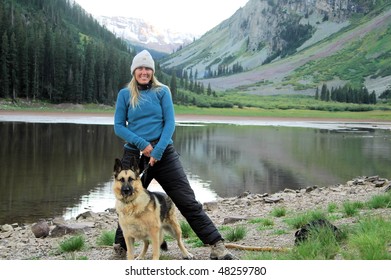 Woman Standing With Dog At Lake