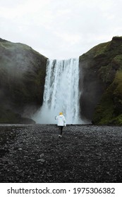 Woman Standing In Front Of Skógafoss Waterfall, Iceland