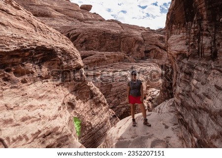 Woman standing in gorge of rock formation with scenic view of limestone rock of Calico Hills near Red Rock Canyon National Conservation Area, Mojave Desert, Las Vegas, Nevada, USA. remote hiking trail