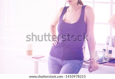 Woman standing with hands folded in her salon