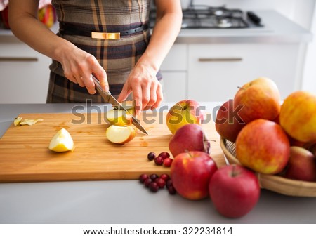 Woman is standing in her kitchen, preparing apples to use to make applesauce and other fruit preserves