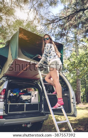 Image, Stock Photo Woman standing in ladder opening tent over car