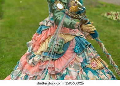 A woman standing in masquerade costume in summer park