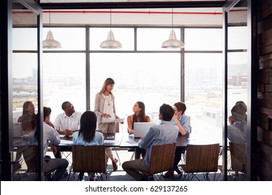 Woman standing at a meeting in a business boardroom