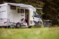 Woman Is Standing With A Mug Of Coffee Near The Camper. Caravan Car Vacation. Family Vacation Travel, Holiday Trip In Motorhome RV
