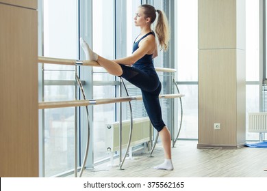 Woman standing near barre in fitness center