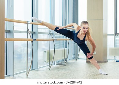 Woman Standing Near Barre In Fitness Center