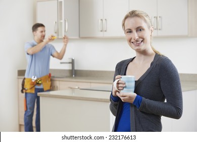 Woman Standing In New Luxury Fitted Kitchen