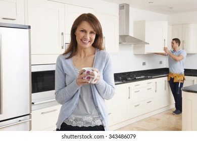 Woman Standing In New Luxury Fitted Kitchen