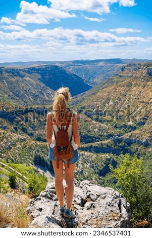 Woman standing on cliff enjoying beautiful panoramic canyon landscape- hiking, adventure, travel concept