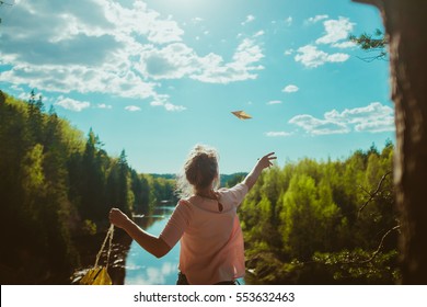 Woman Standing On Cliff And Throwing Paper Plane 