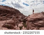 Woman standing on edge of rock formation with scenic view of limestone rock of Calico Hills near Red Rock Canyon National Conservation Area, Mojave Desert, Las Vegas, Nevada, USA. remote hiking trail