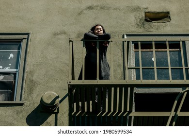 Woman Standing On Fire Escape During The Coronavirus Lockdown