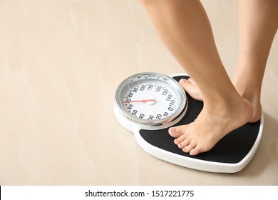 Woman standing on floor scales indoors, space for text. Overweight problem