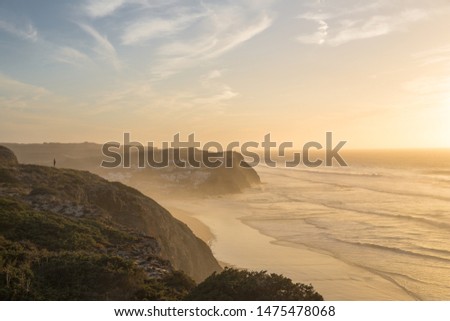 Woman standing on the hill front of the ocean at Portugal