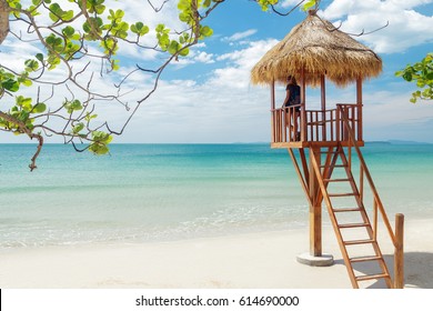 Woman standing on lifeguard tower on the sand beach in Cambodia