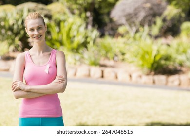 Mujer de pie en el camino en el parque con licras de color verde azulado y cinta de conciencia rosa, espacio de copia. Fitness, al aire libre, estilo de vida saludable, serenidad, naturaleza, atlético, bienestar