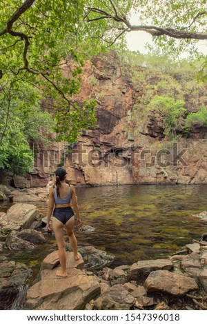 A woman standing on the shore of Billabong Florence Falls in Litchfield National Park