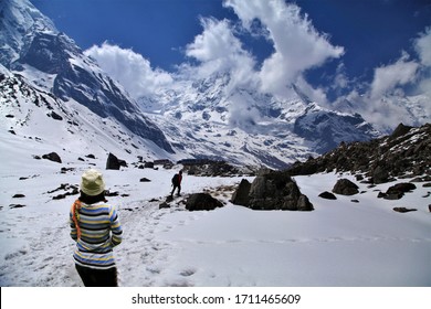 Woman Standing On Snow,Trekker Walking Mountain Peak On The Annapurna Base Camp Trekking Route,abc Mountain Nepal.