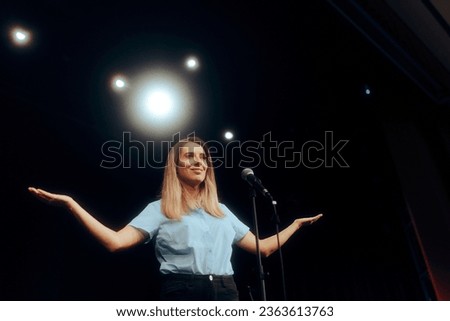 
Woman Standing on a Stage Speaking on the Microphone. Motivational speaker talking about success and mindfulness to public audience 
