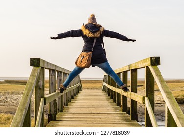 Woman is standing on wooden bridge