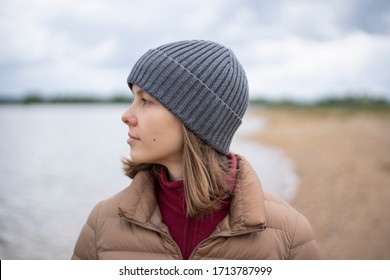 
Woman standing at river bank looking away